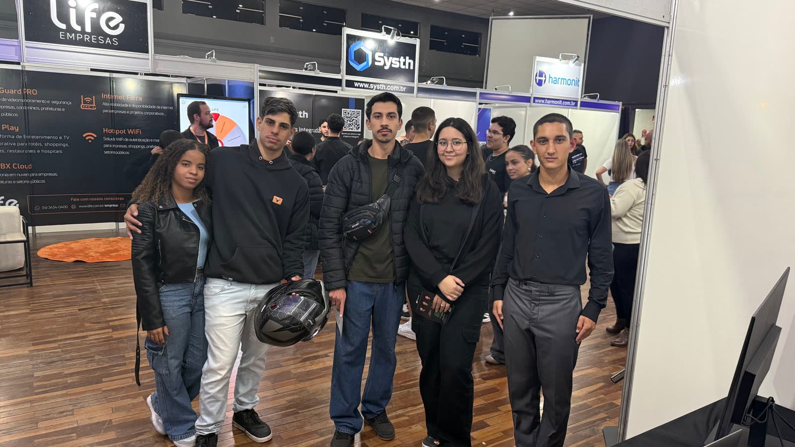 Estande da Mavellium na FITEC 2026 — Isabella interagindo com o Janus CMS para análise de dados com GA4 e Clarity