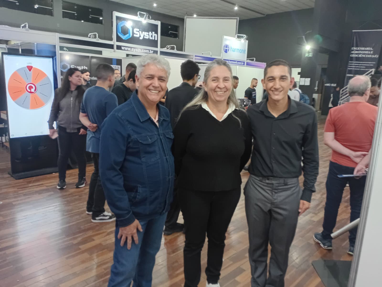 Estande da Mavellium na FITEC 2026 — Andréia da Silva Piva interagindo com o Janus CMS para análise de dados com GA4 e Clarity